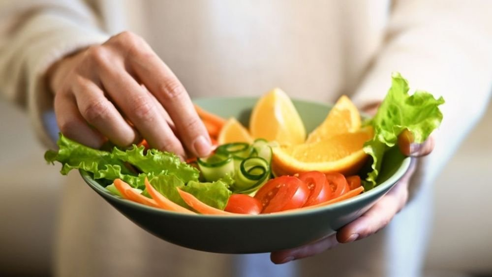 Frau hält eine Schüssel mit frischem, gesundem Salat